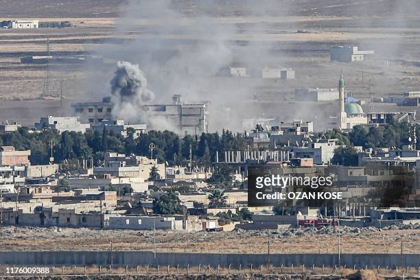 This picture taken on October 15, 2019 from the Turkish side of the border at Ceylanpinar district in Sanliurfa shows smoke rising from the Syrian...