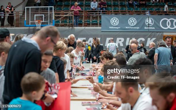Players gives autographs during the test match between s.Oliver Wuerzburg and Darussafaka Istanbul at s.Oliver Arena on September 12, 2019 in...
