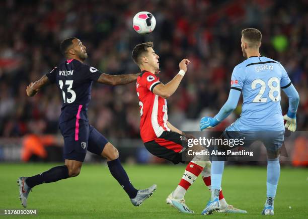 Callum Wilson of AFC Bournemouth puts pressure on Jan Bednarek of Southampton and later goes onto to score his sides third goal as Angus Gunn of...