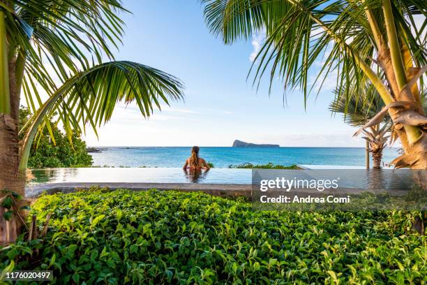 rear view of a young woman in a infinity pool - islands imagens e fotografias de stock