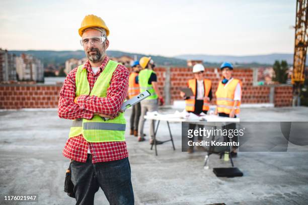 the taskmaster with arms crossed on construction site - taskmaster stock pictures, royalty-free photos & images