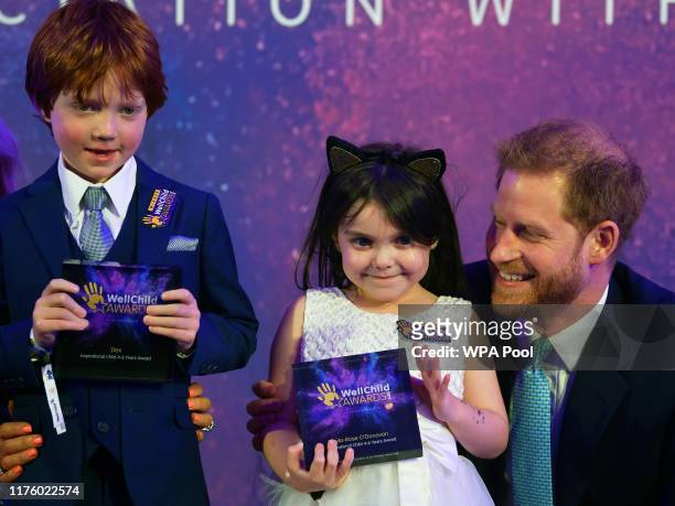 Prince Harry, Duke of Sussex poses for a photograph with award winner Lyla-Rose O'Donovan and co-winner Dexter Spence during the WellChild Awards at...