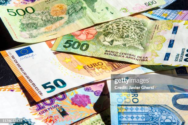 dinero en efectivo: billetes de 20 y 50 euros y billetes de 500 y 100 pesos (argentina) - minimum wage stockfoto's en -beelden