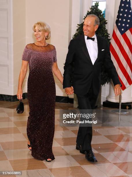 Education Secretary Betsy DeVos, left, and husband Richard DeVos arrive for the State Dinner at The White House honoring Australian PM Morrison on...