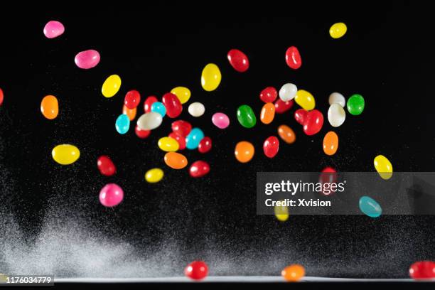 rainbow jelly bean candy jump in mid air captured with high speed sync."n - bala de mascar - fotografias e filmes do acervo