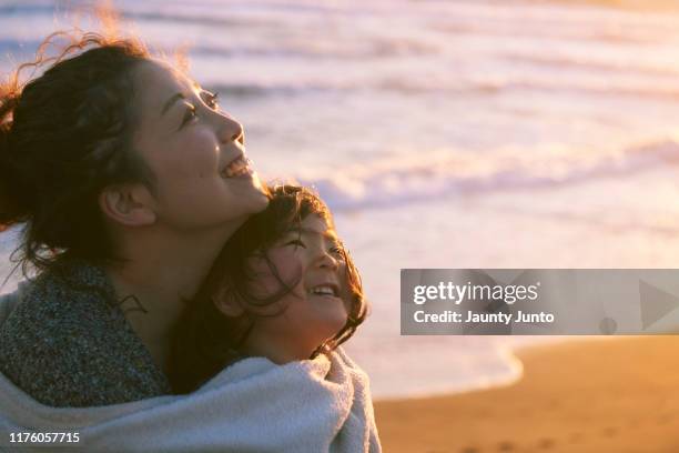 mother and her daughter are holding together in front of the beach - 子供　日本人　笑顔 ストックフォトと画像