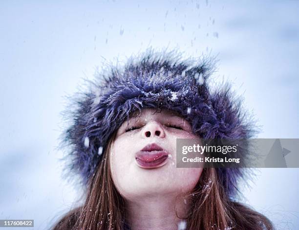 child using her tongue to catch snowflakes - fur hat stock pictures, royalty-free photos & images