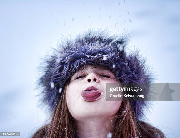 child using her tongue to catch snowflakes - chapéu de pêlo de animal imagens e fotografias de stock