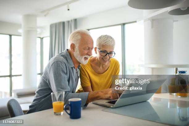 mature couple buying some goods online - old woman short hair stock pictures, royalty-free photos & images