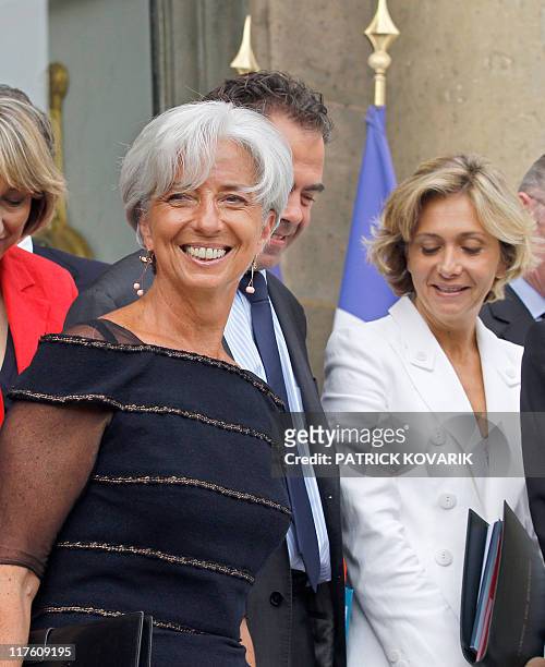 France's former Finance minister Christine Lagarde who was named the day before the first-ever female chief of the IMF, smiles surrounded by her...