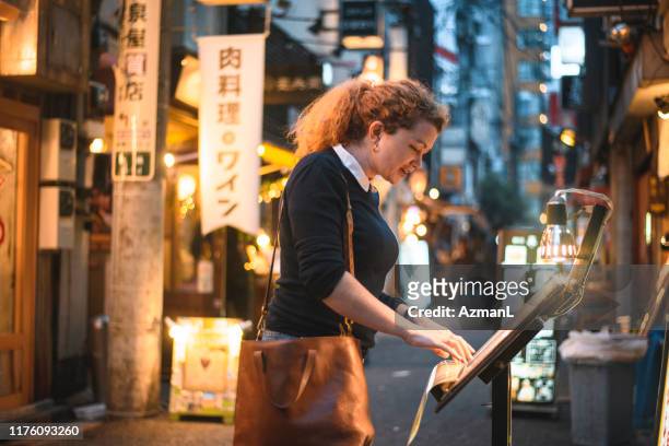caucasian traveler checking menü außerhalb tokyo restaurant - restaurant strasse stock-fotos und bilder