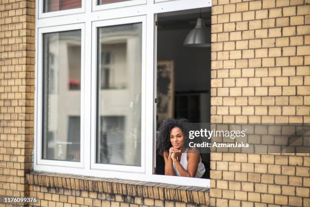 contented african businesswoman standing at window - open window frame stock pictures, royalty-free photos & images