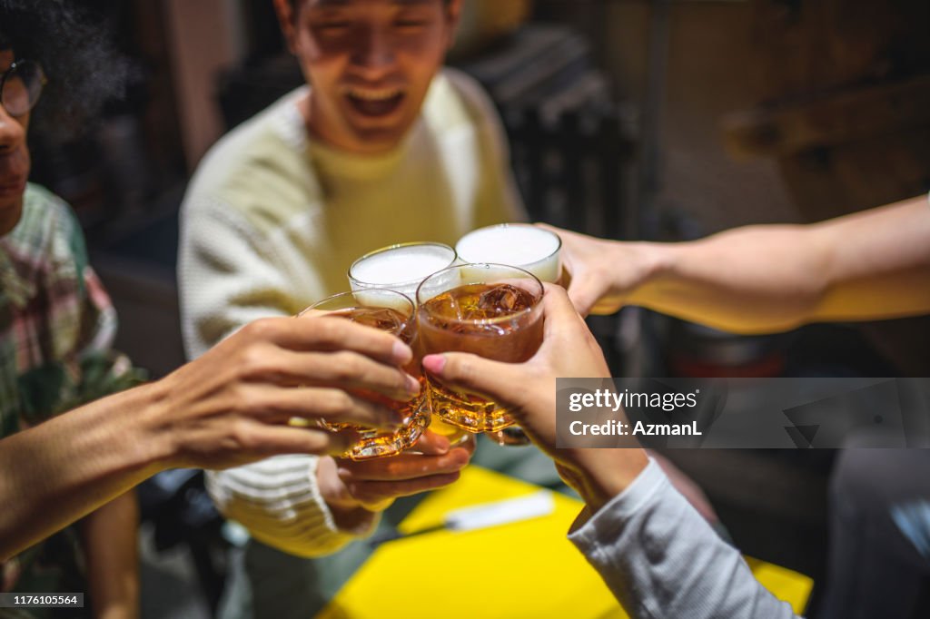 居酒屋でお祝いの乾杯で育てた飲み物のクローズアップ