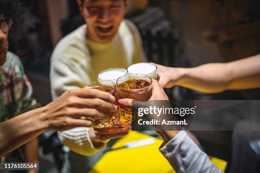 居酒屋でお祝いの乾杯で育てた飲み物のクローズアップ 居酒屋でお祝いの乾杯で育てた飲み物のクローズアップ