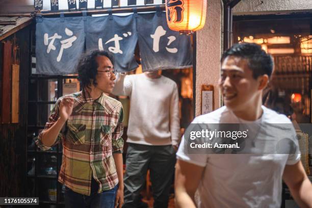 smiling young japanese male friends leaving tokyo izakaya - leaving restaurant stock pictures, royalty-free photos & images