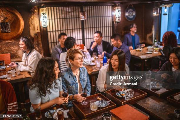 high angle view of female friends sitting at tokyo sushi bar - sushi restaurant interior stock pictures, royalty-free photos & images