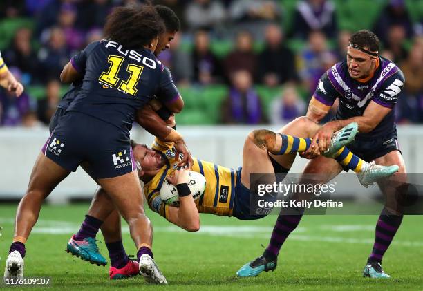 Clinton Gutherson of the Eels is tackled by Dale Finucane of the Storm , Tui Kamikamica of the Storm and Felise Kaufusi of the Storm during the NRL...
