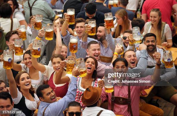 Revelers cheer with 1-liter-mugs of beer during the opening weekend of the 2019 Oktoberfest on September 21, 2019 in Munich, Germany. This year's...
