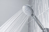 Water running from shower head and faucet in modern bathroom.