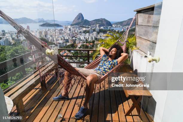 ung man sover i hängmatta på balkongen i rio - sugar loaf bildbanksfoton och bilder
