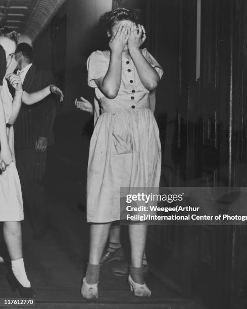 Runaway girl covers her face, after police officers captured her after she and four others escaped from the Florence Crittenton Home, 26th August...