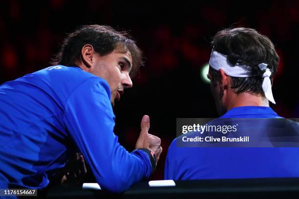 Rafael Nadal of Team Europe speaks to teammate Roger Federer as he sits down during his singles match against Nick Kyrgios of Team World during Day...