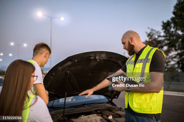 car mechanic helping young couple in trouble - vehicle breakdown stock pictures, royalty-free photos & images