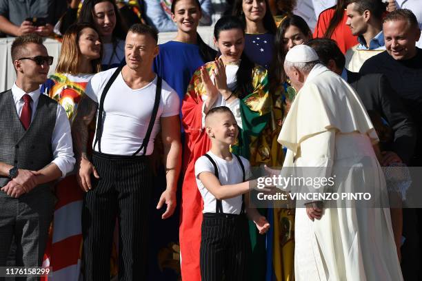 Pope Francis shakes hand with a boy as he meets with members of a circus taking part in an Italian circus festival, during the weekly general...