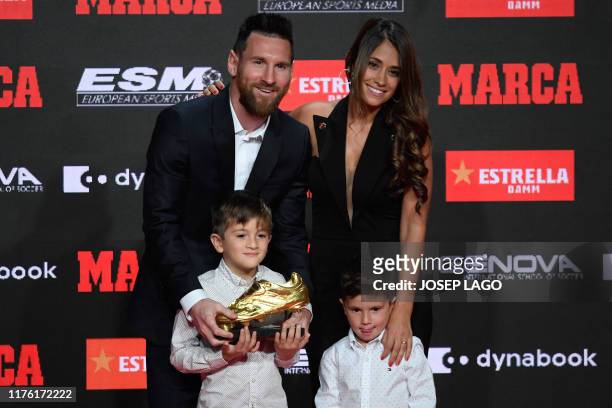 Barcelona's Argentinian forward Lionel Messi poses with his wife Antonella Roccuzzo and his sons Thiago and Mateo after receiving his sixth Golden...