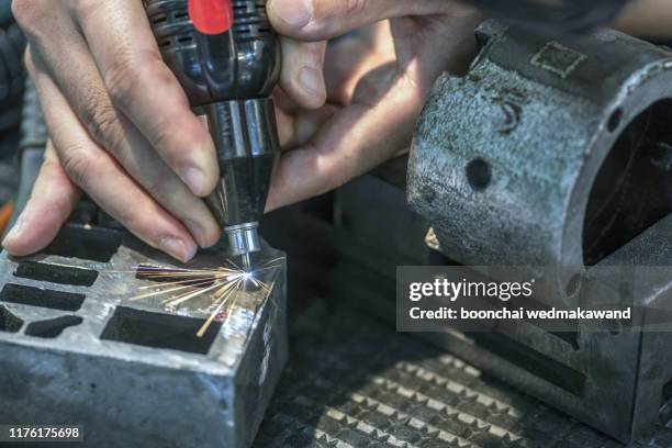 close-up of laser cutting of flat sheet metal steel material with sparks. small depth of field. - laser engraving stock pictures, royalty-free photos & images