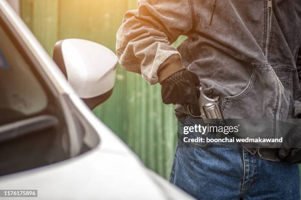 terrorist or a car thief pointing a gun at the driver - car owner - kidnapping 個照片及圖片檔