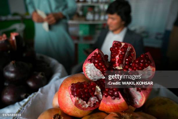 Shopkeeper displays pomegranates during a agricultural products exhibition in Badam Bagh in Kabul on October 16, 2019.