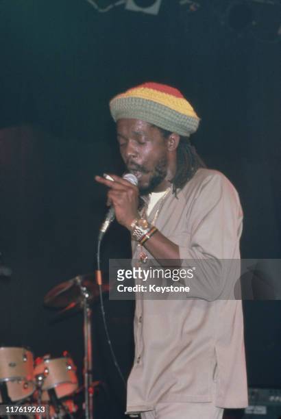 Peter Tosh , Jamaican reggae musician and singer, singing into a microphone during a live concert performance, circa 1985. Tosh was a member of the...