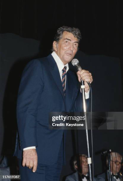 Dean Martin , US singer and actor, singing into a microphone at the Variety Club luncheon, held in his honour, at the Hilton Hotel, in London,...