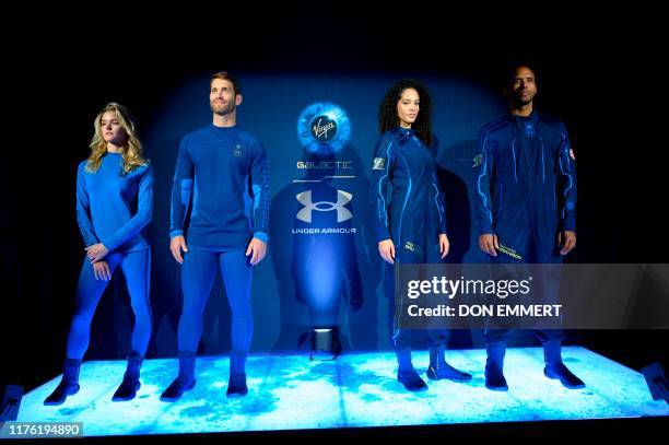 Models wear Virgin Galactic's new space-wear system, developed in partnership with Under Armour, during an event to unveil the suits to be worn by...