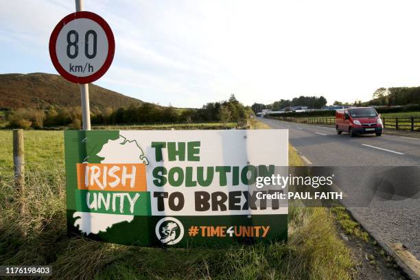 Motorists pass an anti-Brexit Irish Unity banner as they drive in Dundalk, Ireland on October 16 after crossing the border into Dundalk, from Newry...