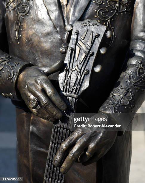 Close up of a bronze statue of country music singer Little Jimmy Dickens in front of the Ryman Auditorium in Nashville, Tennessee.