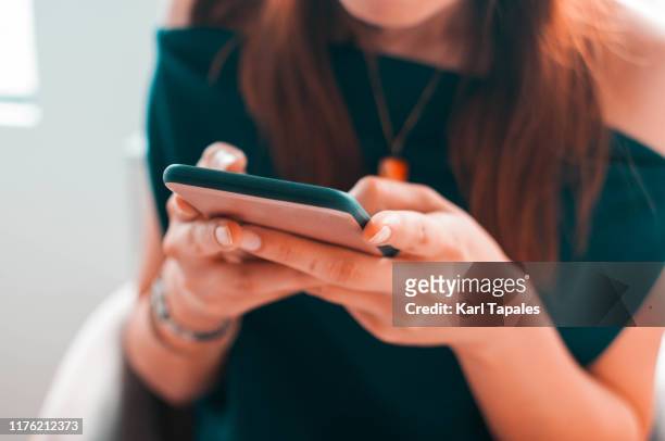 a young woman is using her smartphone - tinder fotografías e imágenes de stock