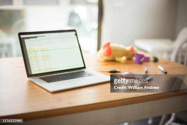 laptop on table with toys, car keys, and mobile device - car keys table stock pictures, royalty-free photos & images