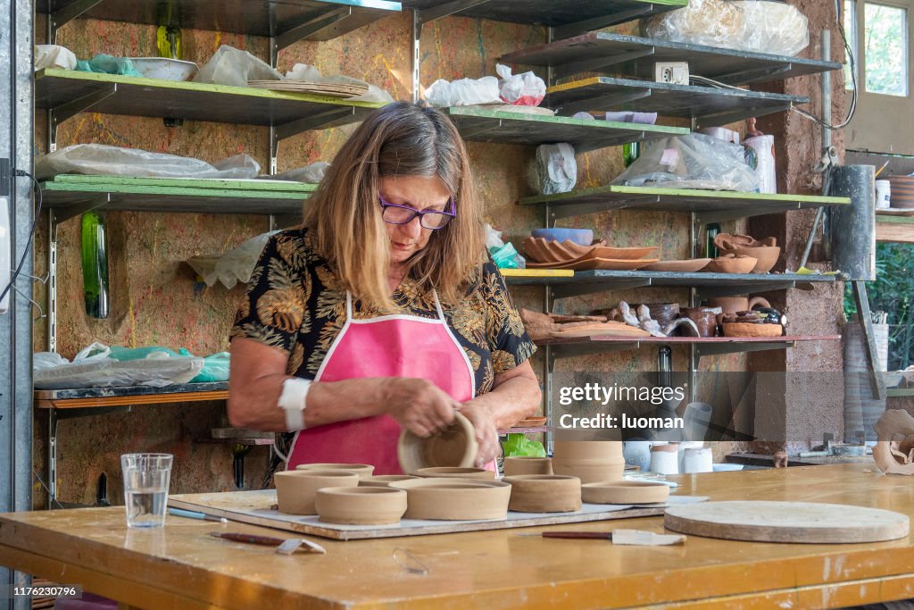 Mulher que trabalha em um estúdio do artesanato