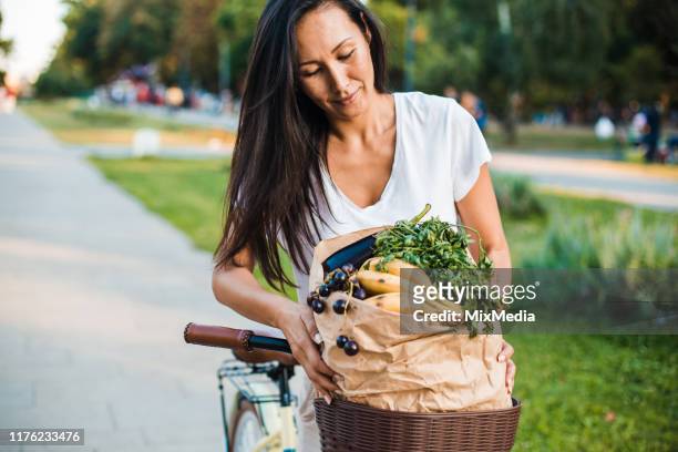 frau im urlaub zurück aus dem gesunden lebensmittelkauf - shopping with bike stock-fotos und bilder