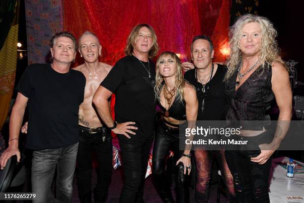Rick Allen, Phil Collen, Joe Elliott, Miley Cyrus, Vivian Campbell, and Rick Savage of Def Leppard attend the 2019 iHeartRadio Music Festival at...