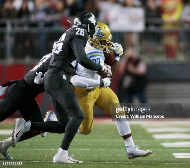 Joshua Kelley of the UCLA Bruins carries the ball against Bryce Beekman of the Washington State Cougars in the second half at Martin Stadium on...