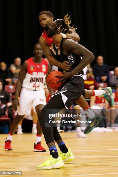 Aaron Brooks of the Hawks fouls Jo Lual Acuil of United during the NBL Blitz pre-season match between Melbourne United and the Illawarra Hawks at...