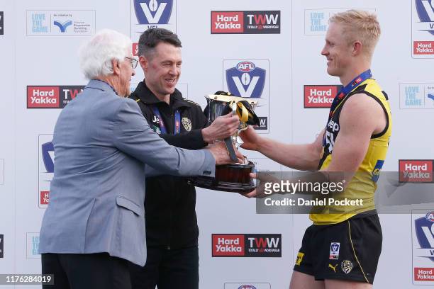 Tigers head coach Craig McRae and Steve Morris of the Tigers are presented with the premiership cup after winning the VFL Grand Final match between...