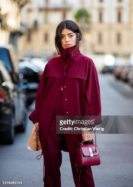 Aida Domenech is seen wearing bordeaux button shirt and pants, bag outside the Ferragamo show during Milan Fashion Week Spring/Summer 2020 on...