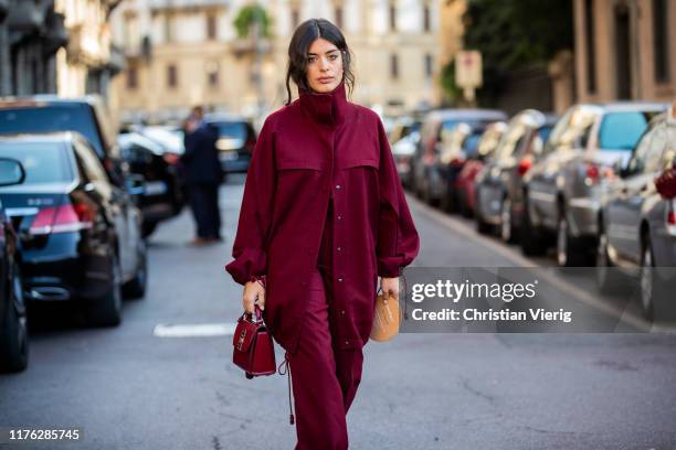 Aida Domenech is seen wearing bordeaux button shirt and pants, bag outside the Ferragamo show during Milan Fashion Week Spring/Summer 2020 on...