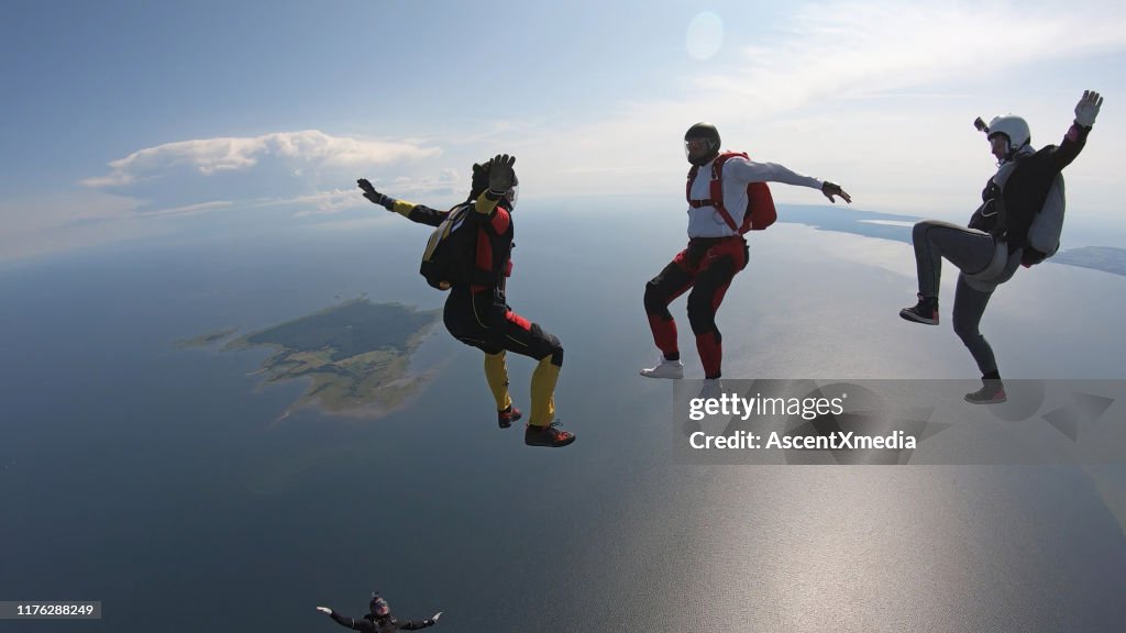 Skydivers fall through clear skies, in aerial flight