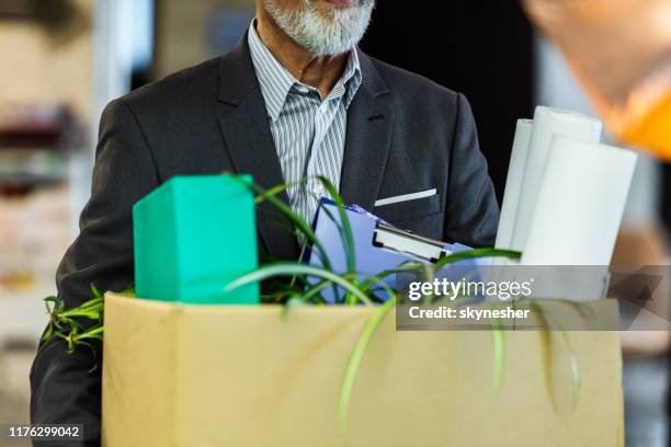 unrecognizable businessman carrying his belongings after being fired. - being fired photos stock pictures, royalty-free photos & images