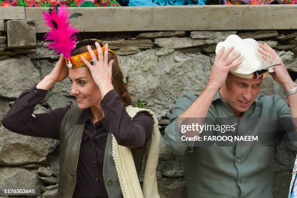 Britain's Prince William , Duke of Cambridge and his wife Catherine, Duchess of Cambridge, adjust traditional Kalash tribe hats on their heads during...